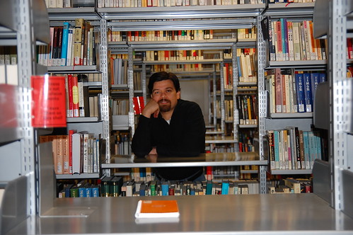 Rogelio Guedea posa entre libreros llenos de libros